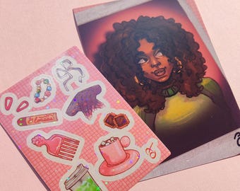 May include: Two items on a pink surface: a sticker sheet and a portrait. The sticker sheet features various pink and iridescent stickers, including a bow, a comb, and a drink. The portrait depicts a person with curly brown hair and gold earrings.