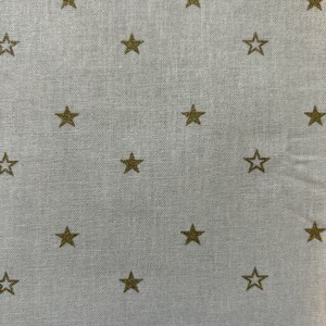 May include: White fabric with a subtle texture, featuring a repeating pattern of gold stars.