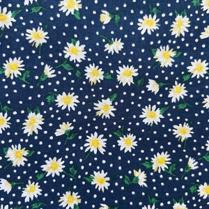 May include: A navy blue fabric with a white daisy pattern and white polka dots.