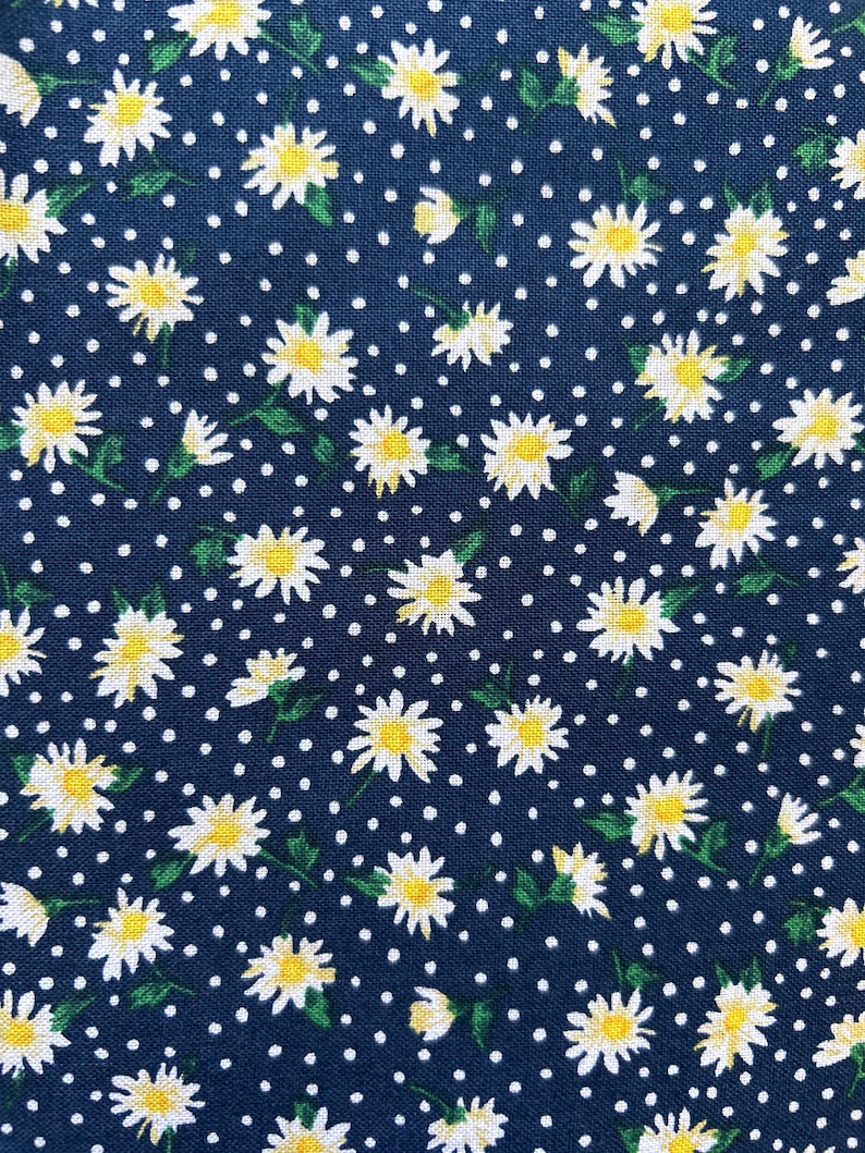 May include: A navy blue fabric with a white daisy pattern and white polka dots.