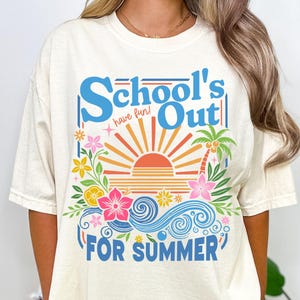 May include: Ivory t-shirt with a vibrant graphic. The design includes the text "School's Out For Summer" in blue, along with a sun, flowers, and palm trees. The words "have fun!" are also included in the design.