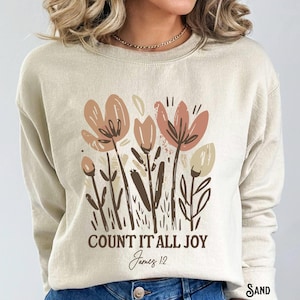May include: A beige sweatshirt with a floral design and the text "COUNT IT ALL JOY James 1:2".