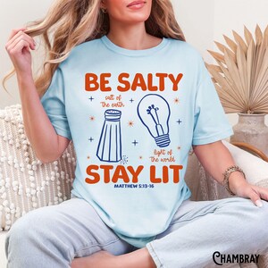 Colores cómodos, camiseta cristiana divertida, camiseta unisex teñida en prenda, Sé salado, mantente iluminado, Sal de la tierra, Luz del mundo, versículo bíblico Chambray