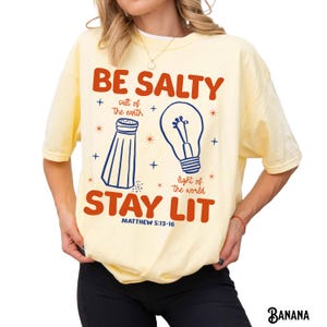 Colores cómodos, camiseta cristiana divertida, camiseta unisex teñida en prenda, Sé salado, mantente iluminado, Sal de la tierra, Luz del mundo, versículo bíblico Banana