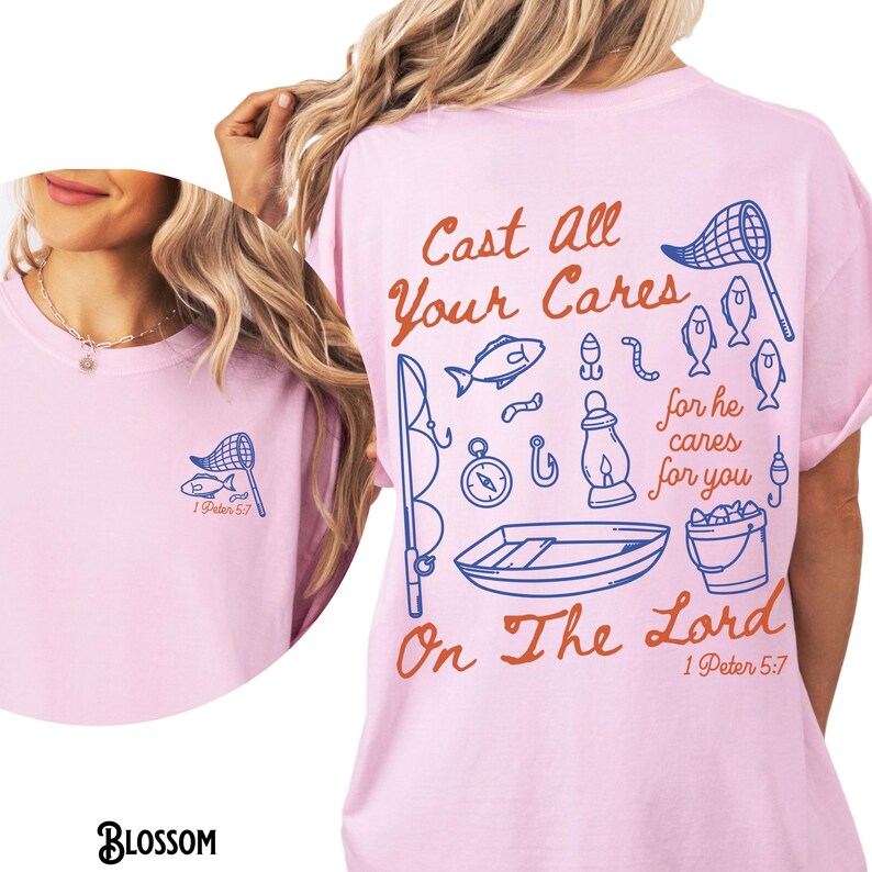 K&ouml;nnte beinhalten: Hellrosa T-Shirt mit einem Angelmotiv. Auf der Vorderseite befindet sich ein kleines blaues Netz- und Fischdesign mit Text. Auf der R&uuml;ckseite befindet sich ein gr&ouml;&szlig;eres Design mit Angelillustrationen und dem Text "Cast All Your Cares On The Lord 1 Peter 5:7."