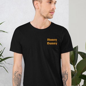 May include: A black t-shirt with the text "Honey Bunny" printed in orange on the front.