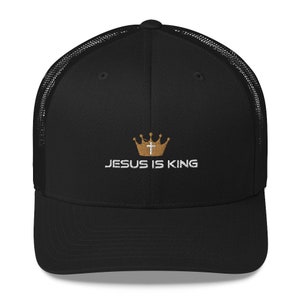 May include: Black trucker hat with a gold crown and cross design. The text "JESUS IS KING" is embroidered in white on the front of the hat.