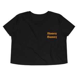 May include: Black cropped t-shirt with the text "Honey Bunny" in orange.