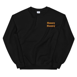 May include: Black sweatshirt with the text "Honey Bunny" in orange on the front.