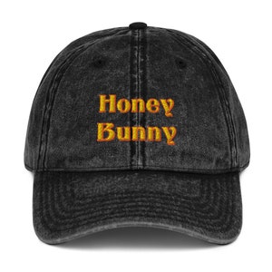 May include: A black vintage washed cotton baseball cap with the text "Honey Bunny" embroidered in orange on the front.
