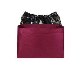 Könnte beinhalten: Burgunderfarbener Filztaschenorganizer mit zwei großen Fächern. Der Organizer ist so konzipiert, dass er in eine Handtasche passt.