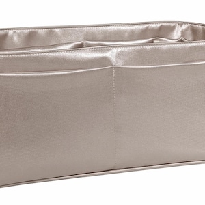 Puede incluir: Organizador de bolso rectangular plateado met&aacute;lico con dos bolsillos delanteros. El interior y el exterior est&aacute;n hechos de un material brillante, similar al sat&eacute;n. El bolso est&aacute; dise&ntilde;ado para caber dentro de un bolso tote o de mano m&aacute;s grande.