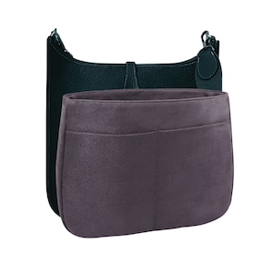 May include: A dark green leather handbag with a gray felt insert. The insert has a large pocket and a smaller pocket.