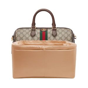 Puede incluir: Organizador de bolso de tela beige con múltiples compartimentos para un bolso de mano. El organizador se muestra dentro de un bolso de mano estampado en marrón y beige con una franja verde y roja.