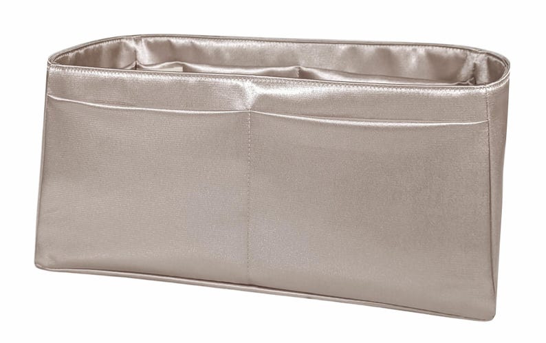 Puede incluir: Organizador de bolso rectangular beige metalizado con dos bolsillos delanteros. El interior y el ribete tienen un acabado satinado. La bolsa est&aacute; dise&ntilde;ada para caber dentro de un bolso tote o un bolso m&aacute;s grande.