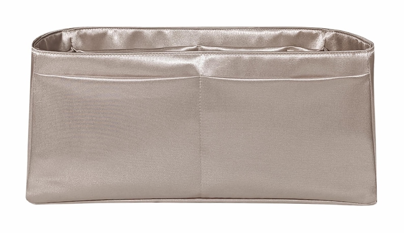 Puede incluir: Organizador de bolso rectangular de color champ&aacute;n claro con dos bolsillos delanteros. El interior es de un tono champ&aacute;n m&aacute;s claro. Fabricado con un material liso similar al sat&eacute;n, dise&ntilde;ado para caber dentro de un bolso m&aacute;s grande.