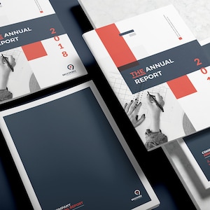 K&ouml;nnte beinhalten: Drei wei&szlig;e und rote Brosch&uuml;ren mit dem Text "The Annual Report 2018" und einem Logo f&uuml;r "Brochures". Die Brosch&uuml;ren liegen &uuml;bereinander gestapelt auf einer wei&szlig;en Oberfl&auml;che.