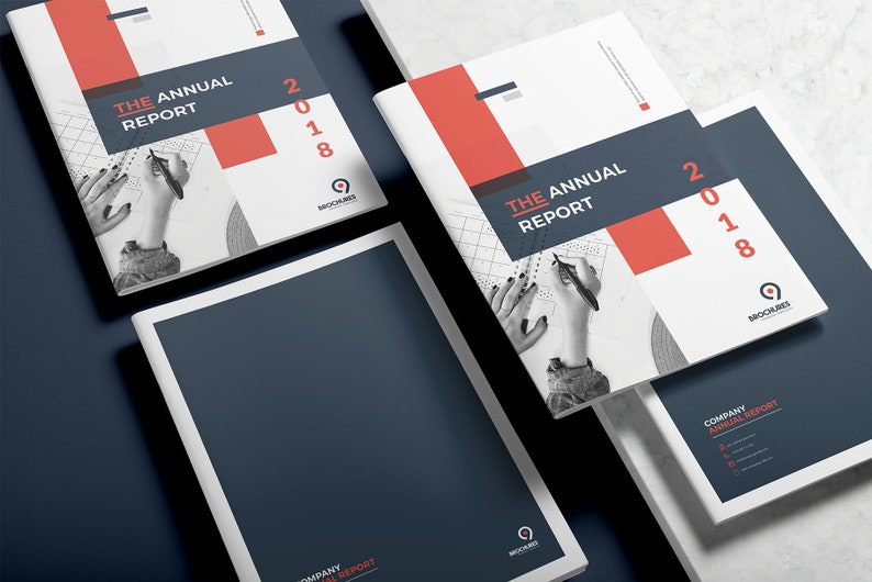 K&ouml;nnte beinhalten: Drei wei&szlig;e und rote Brosch&uuml;ren mit dem Text "The Annual Report 2018" und einem Logo f&uuml;r "Brochures". Die Brosch&uuml;ren liegen &uuml;bereinander gestapelt auf einer wei&szlig;en Oberfl&auml;che.