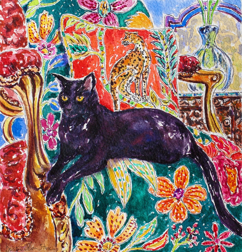 Puede incluir: Pintura a la acuarela de un gato negro con ojos amarillos, reclinado sobre un coj&iacute;n con estampado floral. El fondo incluye una almohada roja con un dise&ntilde;o de guepardo, un jarr&oacute;n y otros elementos decorativos. La obra de arte tiene una paleta de colores vibrantes.