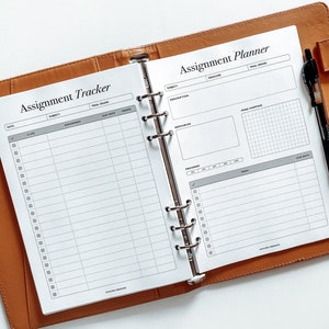 Puede incluir: Un planificador blanco con una cubierta de cuero marr&oacute;n. El planificador est&aacute; abierto en dos p&aacute;ginas. La p&aacute;gina izquierda est&aacute; etiquetada como "Assignment Tracker" y tiene columnas para la fecha, la clase, la tarea, la fecha de entrega y la calificaci&oacute;n. La p&aacute;gina derecha est&aacute; etiquetada como "Assignment Planner" y tiene secciones para la materia, la descripci&oacute;n, los recursos, el progreso, las tareas y la fecha de entrega. Hay una cuadr&iacute;cula para marcar el progreso.