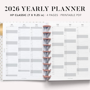 May include: An open 2026 yearly planner with a white interior and grey and white grid layouts for each month. The planner is labeled "HP CLASSIC (17.78 x 23.5 cm)" and includes the text "2026 YEARLY PLANNER". The planner is bound with a rose gold coil.