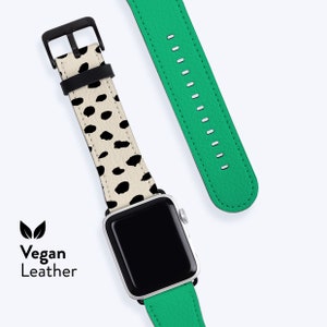 Peut inclure: Un bracelet de montre à pois noir et blanc avec un bracelet de montre vert attaché à une Apple Watch argentée. Le bracelet de montre est en cuir végétalien et porte l'inscription "Vegan Leather" imprimée sur l'image.