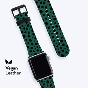 May include: An Apple Watch with a green vegan leather strap featuring a black spotted pattern. The watch is connected to the strap and a separate strap piece. The words "Vegan Leather" are printed on the left side of the image.