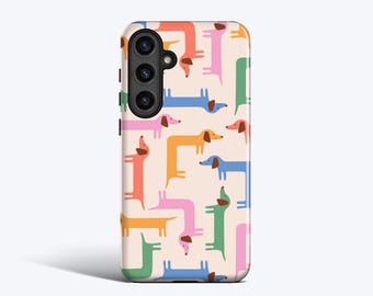 Może przedstawiać: Etui na telefon z powtarzającym się wzorem kolorowych jamników. Psy są w odcieniach różu, pomarańczy, niebieskiego, zielonego i żółtego na jasnobeżowym tle. Etui ma moduł aparatu w lewym górnym rogu.