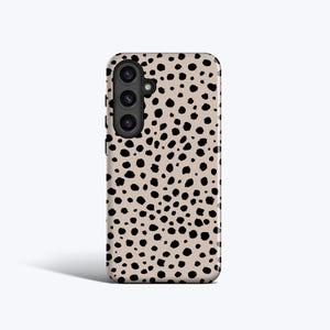 May include: A mobile phone case featuring a beige backdrop adorned with a pattern of black spots. The case incorporates a camera module with three lenses. The design evokes a cheetah's coat.