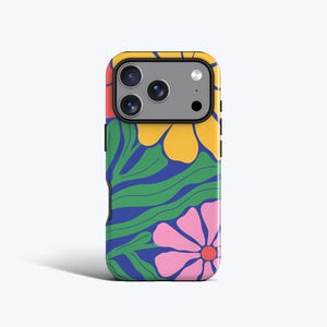 May include: A patterned phone case with a floral design. The case features large yellow and pink flowers, green leaves, and a blue background. The phone case has a black border and a camera cutout.