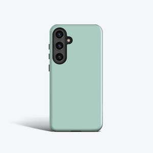 May include: A pale green phone case featuring a triple-lens camera unit on the upper left. The case has a smooth, matte finish and a minimalist design. The camera module is black.