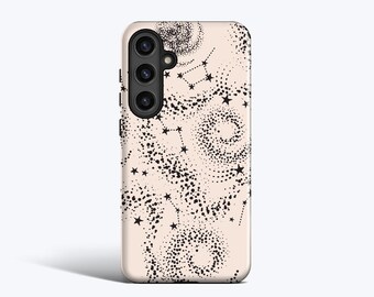 May include: A phone case with a light pink background and a black celestial design. The design includes constellations, stars, and dotted spiral patterns. The phone case has a black camera module on the upper left side.