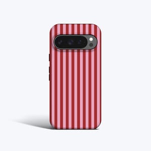 May include: A red and pink striped phone case with a black camera lens.