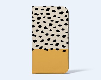 May include: A rectangular phone case with a two-tone design. The top portion features a cream background with scattered black spots, while the bottom half is a solid mustard yellow. The case has rounded corners.