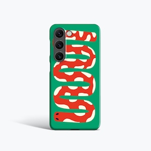 Può includere: Una custodia per telefono verde con un design a serpente rosso e bianco. Il serpente è stilizzato con un motivo ripetuto di cerchi bianchi. La custodia del telefono ha un modulo fotocamera con tre obiettivi.