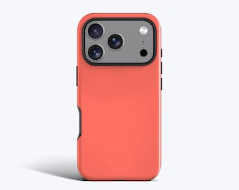 May include: A coral-colored smartphone case featuring a rectangular camera module cutout with a gray border. The case has a smooth, solid-colored back panel and black side buttons, designed to fit a device with a triple-lens camera system.