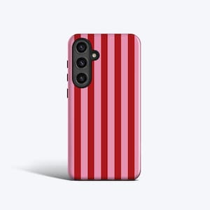 May include: A red and pink striped phone case with a black camera lens.