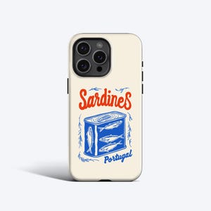 Puede incluir: Una funda de iPhone blanca con una ilustración azul y blanca de una lata de sardinas. El texto "Sardines Portugal" está impreso en la funda en rojo y azul.