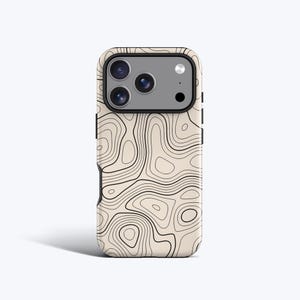 Può includere: Una custodia per smartphone con sfondo beige e un motivo a linee di mappa topografica nere. La custodia presenta un ritaglio rettangolare per la fotocamera, che rivela un sistema a tripla lente con flash e un piccolo sensore su pannello grigio.