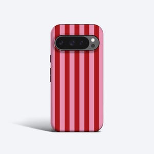 Può includere: Custodia per telefono con motivo a righe verticali in tonalità rosse e rosa alternate. La custodia ha un ritaglio per la fotocamera nella parte superiore ed è progettata per uno smartphone.
