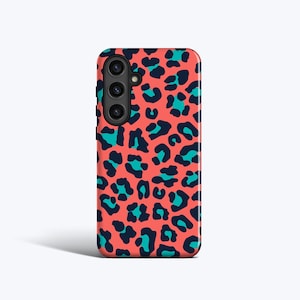 Puede incluir: Funda de teléfono de color coral con un estampado de leopardo en azul turquesa y azul marino. La funda tiene un módulo de cámara en la parte superior izquierda. El diseño cubre toda la superficie de la funda.