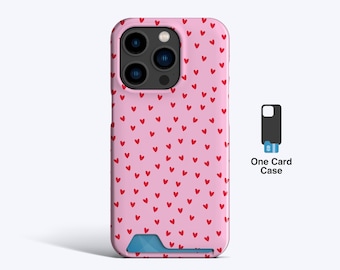 May include: Pink phone case with a pattern of small red hearts. The case has a built-in card holder and a camera cutout. The text "One Card Case" is printed on the side.
