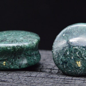 Puede incluir: Par de medidores de oreja de piedra de ágata verde. Los medidores tienen un patrón de remolino y mármol.