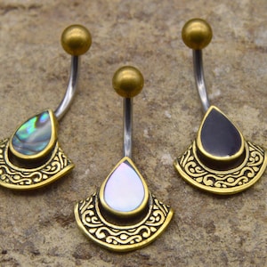 May include: Three belly button rings with gold-toned metal accents and different coloured teardrop-shaped stones. The stones are iridescent, black, and white.