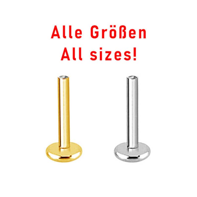 May include: Two labret studs, one gold and one silver, with flat ends. The text "Alle Gr&ouml;&szlig;en All sizes!" is above the studs.