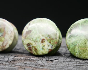 May include: Three round green and brown stone plugs for stretched earlobes.