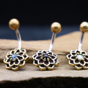 May include: Five belly button rings with a gold flower design and a jeweled center. The jewels are turquoise, blue, black, white, and clear.
