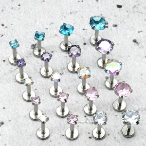 Può includere: Assortimento di 16 gioielli per il corpo in acciaio inossidabile con pietre preziose di vari colori. Le pietre preziose sono in tonalità di blu, viola, rosa e trasparente.