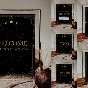 May include: Set of six black and gold wedding signs with celestial moon and star designs. The signs include "Welcome", "Capture the Love", "Selfie Station", "Food", "Guestbook", and "Favors".