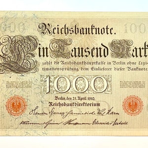 May include: A vintage German Reichsbanknote for 1000 Mark, dated April 21, 1910. The note features intricate floral designs and the text "Reichsbanknote" and "Ein Tausend Mark".